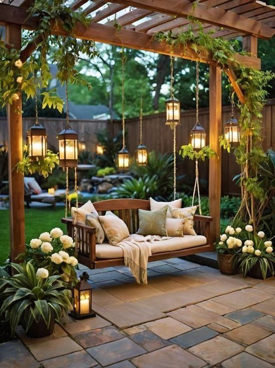 a wooden bench sitting under a pergoline covered arbor with hanging lights and flowers