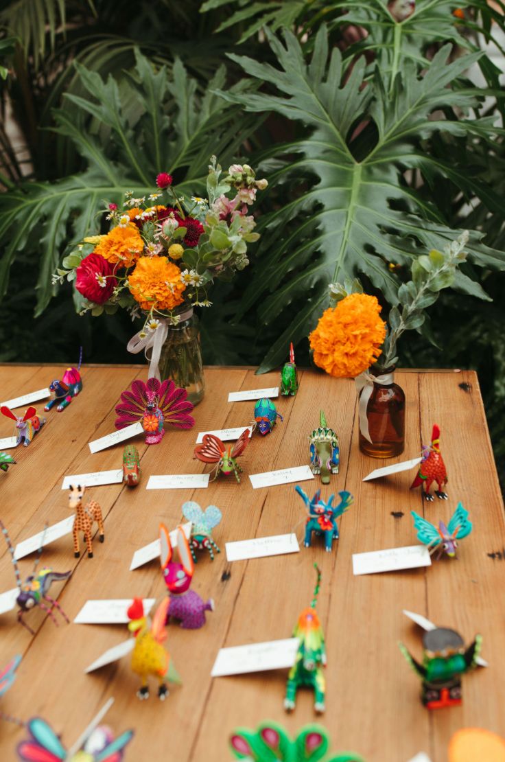 the table is covered with many colorful decorations and paper flowers in vases next to each other