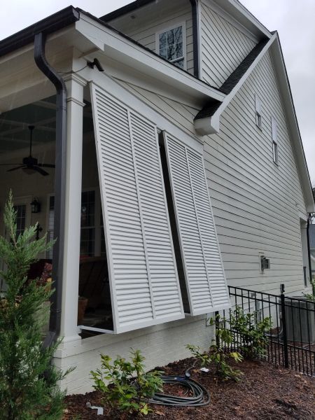 a white house with shutters on the front and side windows that have been partially closed