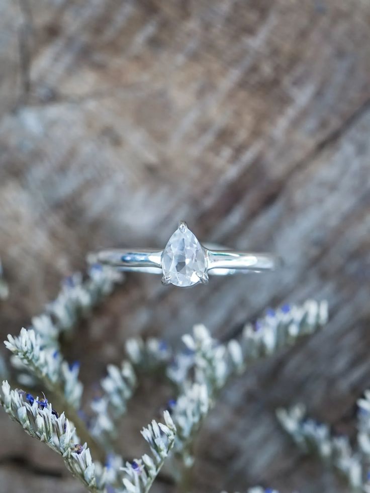 Highlighting a clear white pear-shaped gemstone delicately cradled in a basket prong setting.This pear topaz ring can also serve as a placeholder ring or stand-in ring, embodying the anticipation and excitement of what the future holds. Topaz is the November birthstone. Each piece of our jewelry is handcrafted with love. Silver Solitaire Teardrop Ring, Promise Teardrop Ring With Prong Setting, Silver Teardrop Topaz Promise Ring, Teardrop Topaz Ring For Anniversary, Promise Ring With Teardrop Prong Setting, Teardrop Moonstone Promise Ring, Diamond White Solitaire Teardrop Ring, Silver Pear-shaped Solitaire Jewelry, Anniversary Teardrop Topaz Ring