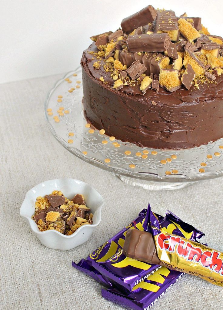 there is a chocolate cake on the table with two small bowls and one large piece of candy