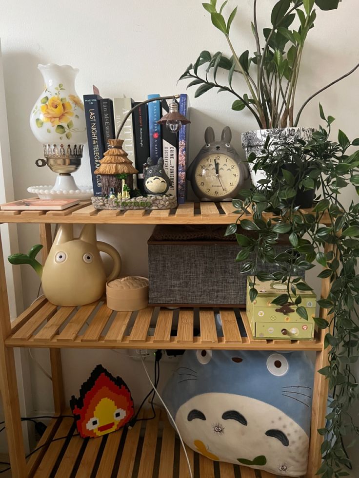 a shelf with books, plants and other decorative items on it next to a potted plant