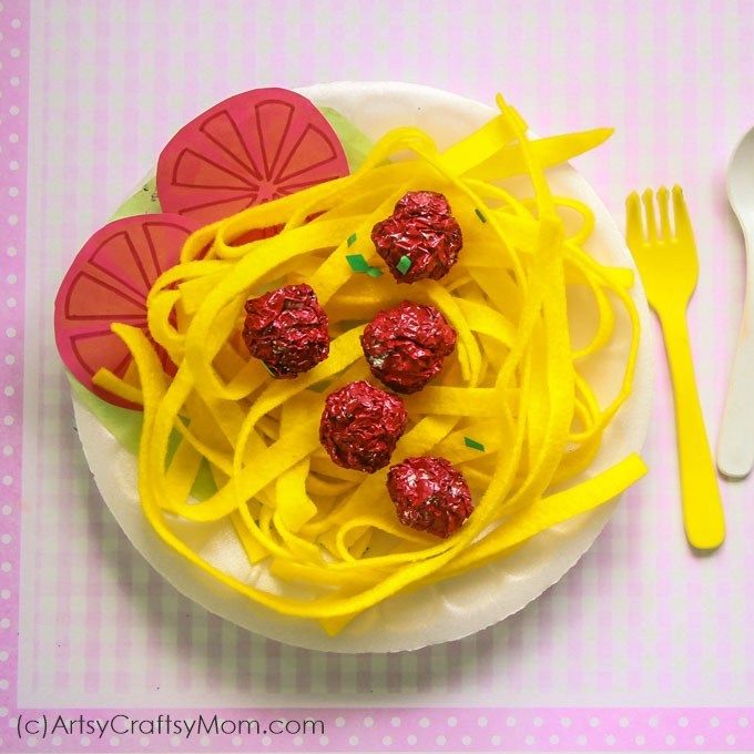 a plate topped with pasta and raspberries on top of a table next to a fork