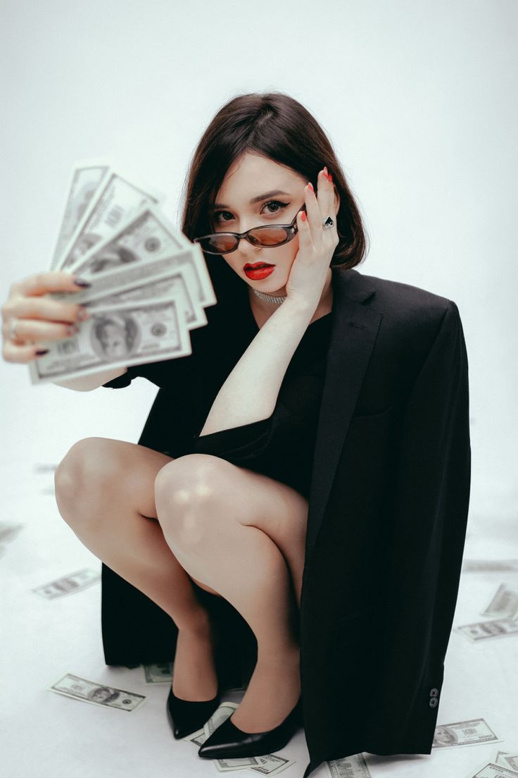 a woman sitting on the ground with money in her hands