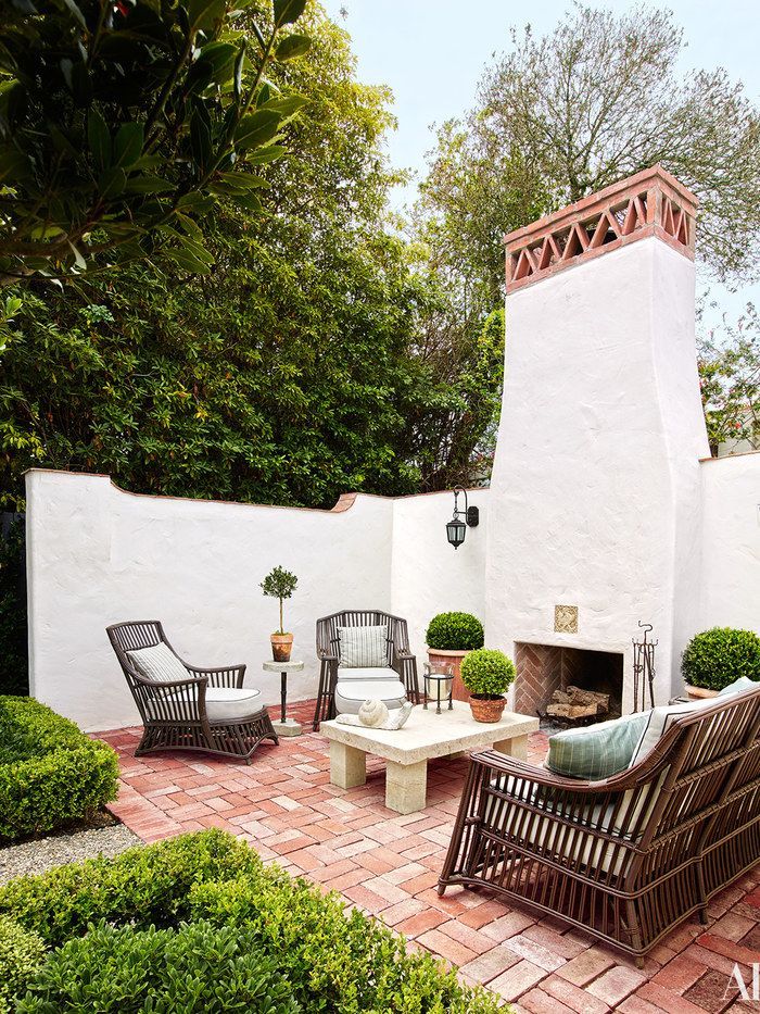 an outdoor patio with chairs, tables and a fire place