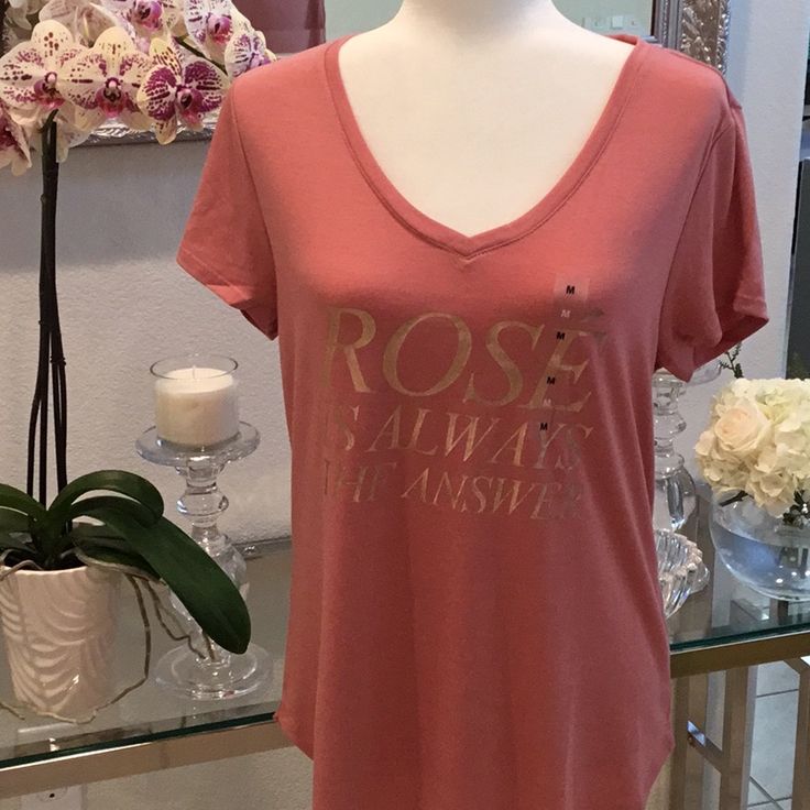 Super Soft Short Sleeve T-Shirt With Gold Lettering That Says Rose Is Always The Answer. This T-Shirt Is So Soft. I Have The Exact Same Shirt But In Small. This One Is A Medium. New With Tags And Has Never Been Worn. The T-Shirt Is A Little Bit On The Long Side. I Would Say It Kind Of Goes Past The Hips At Least On Me. I’m Not Very Tall. Gorgeous Dusty Rose Color. Gold Lettering. V-Neck. The Fabric Is Super Soft. And Rose Is Always The Answer For Everything!. Non-Smoking Household Fast Shipper Rose Print Tops For Summer, Summer Graphic Tee With Rose Print, Rose Color Crew Neck Top With Rose Print, Casual Rose Cotton Top, Short Sleeve Rose Print Graphic Tee Tops, Casual Rose Print Tops In Rose Color, Casual Rose Print Tops, Casual Pink T-shirt With Rose Print, Casual Pink Rose Print T-shirt