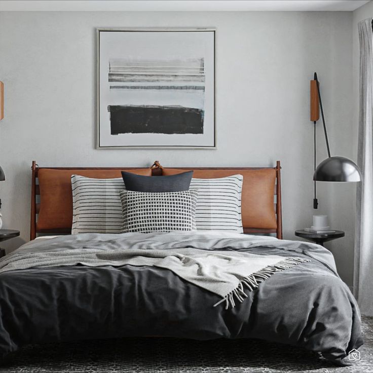 a bed sitting in a bedroom next to a desk with a lamp on it and a painting hanging above the bed