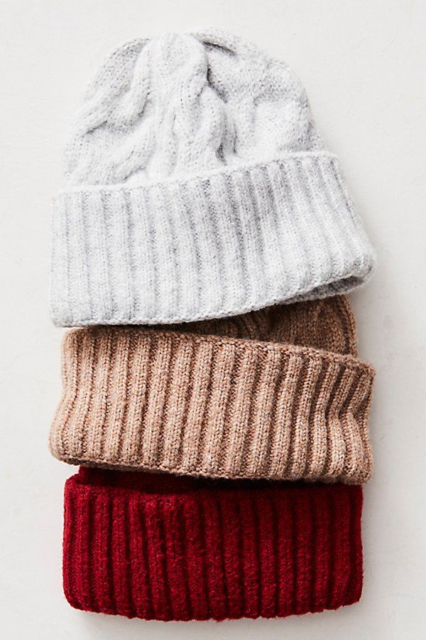 three knit beanies are lined up on top of each other in different colors and sizes