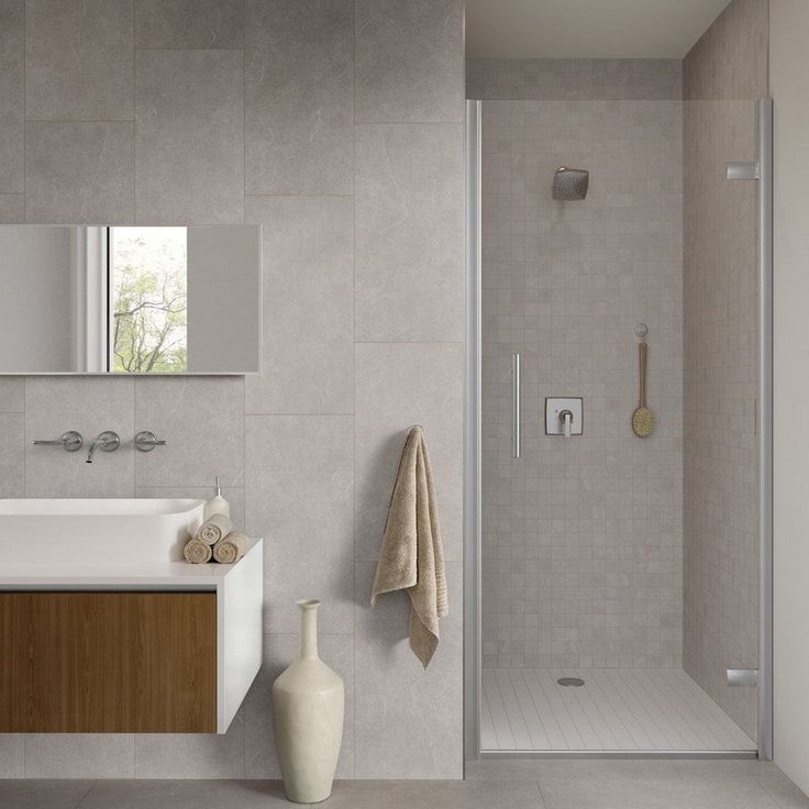 a bathroom with a sink, mirror and shower in it's center wall is shown