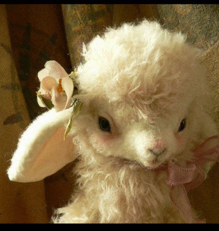 a white stuffed animal with a flower in its hair