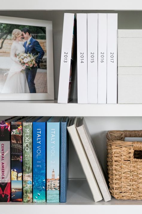 the books are lined up on the shelves with pictures and baskets in front of them