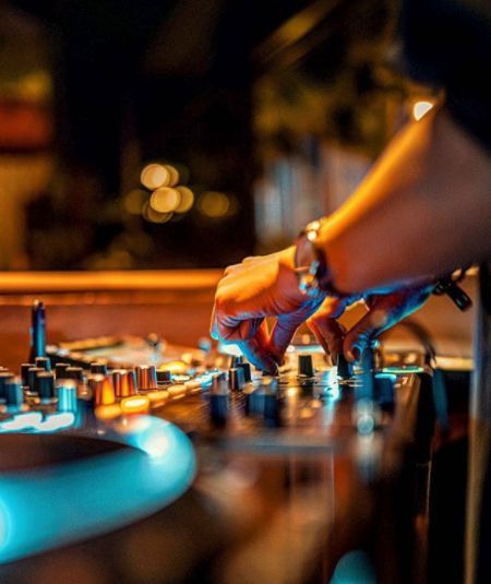 a dj mixing music on a turntable in a nightclub or club with blue lights