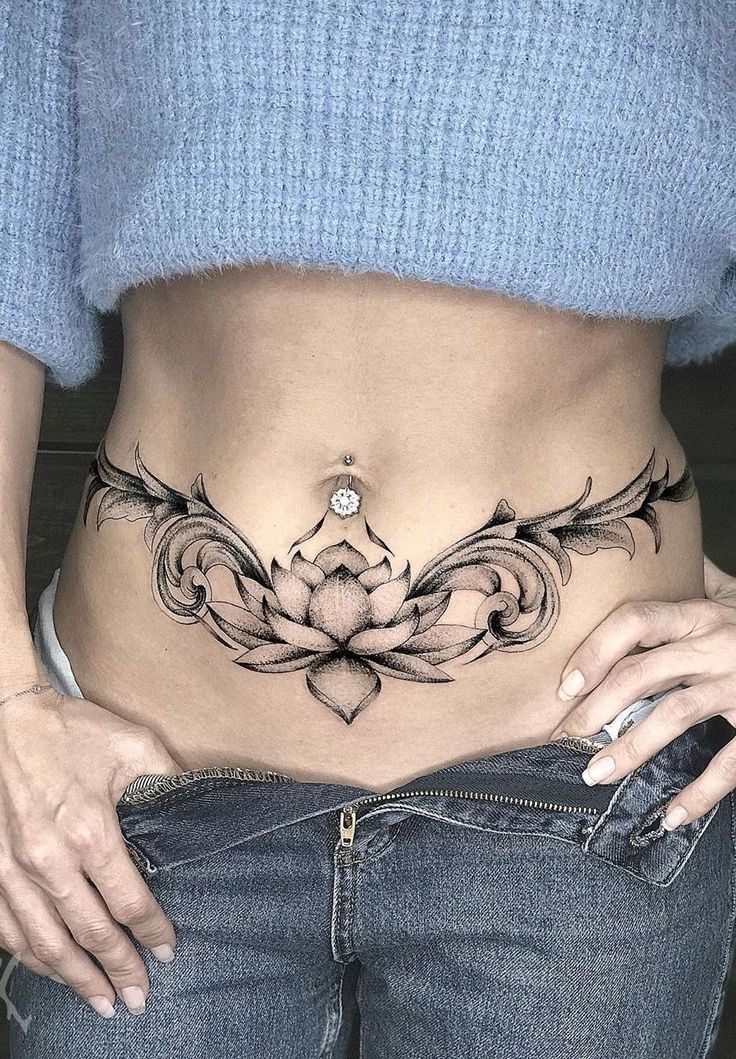 a woman's stomach with a lotus tattoo on her lower body and the bottom part of her stomach