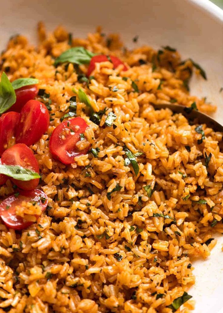 a white bowl filled with rice and tomatoes