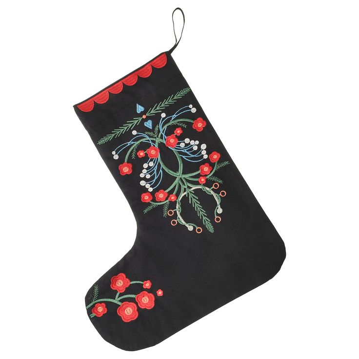 a black christmas stocking with red berries and leaves