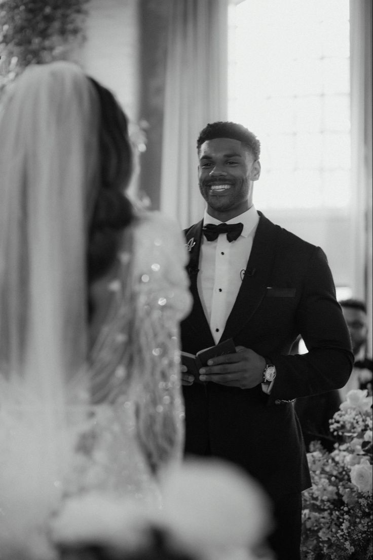 a man in a tuxedo smiles at his bride