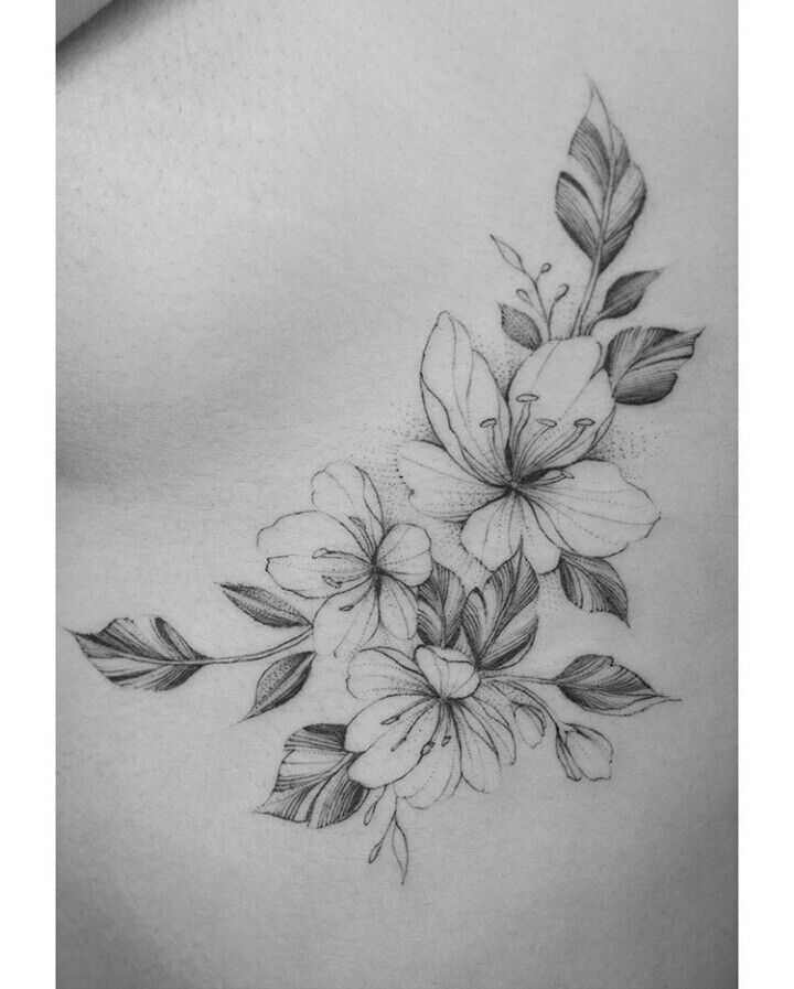 a woman's stomach with flowers and leaves drawn on the side by tattoo artist