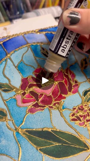 someone is painting flowers on a mosaic with acrylic paint