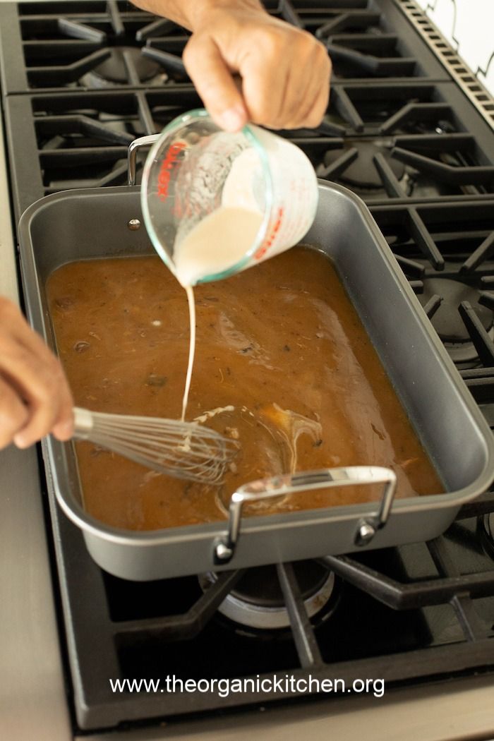 someone is pouring sauce into a pan on the stove