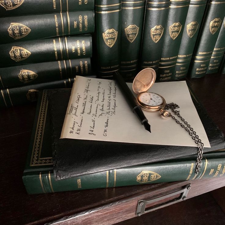 an open book with a pocket watch sitting on top of it next to some books