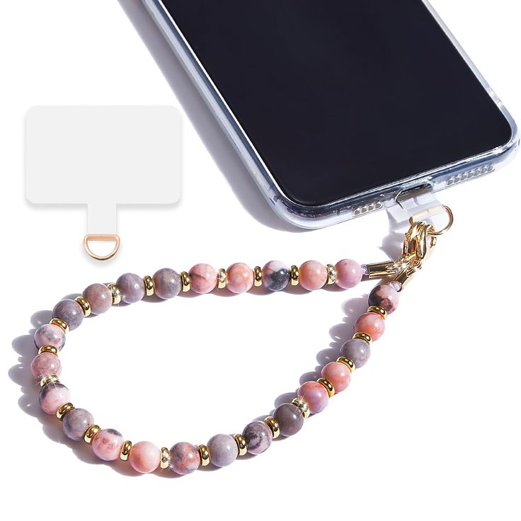 a cell phone with a pink beaded lanyard attached to it next to a gold chain