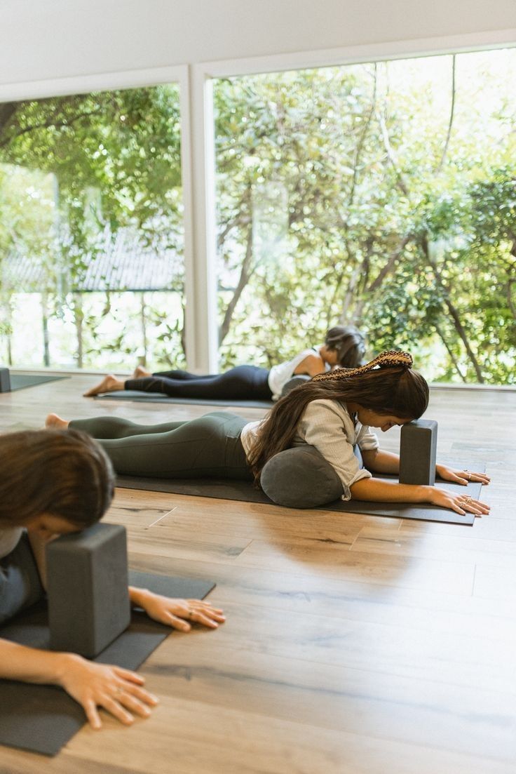 group of people doing yoga on their stomachs in the middle of an open floored room