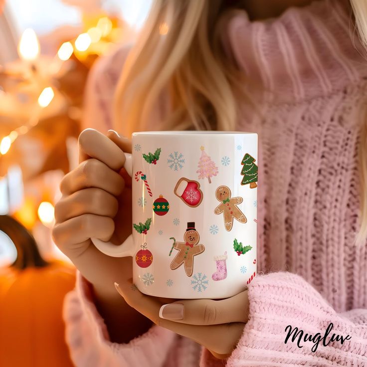 a woman is holding a coffee mug decorated with christmas decorations and gingerbreads on it