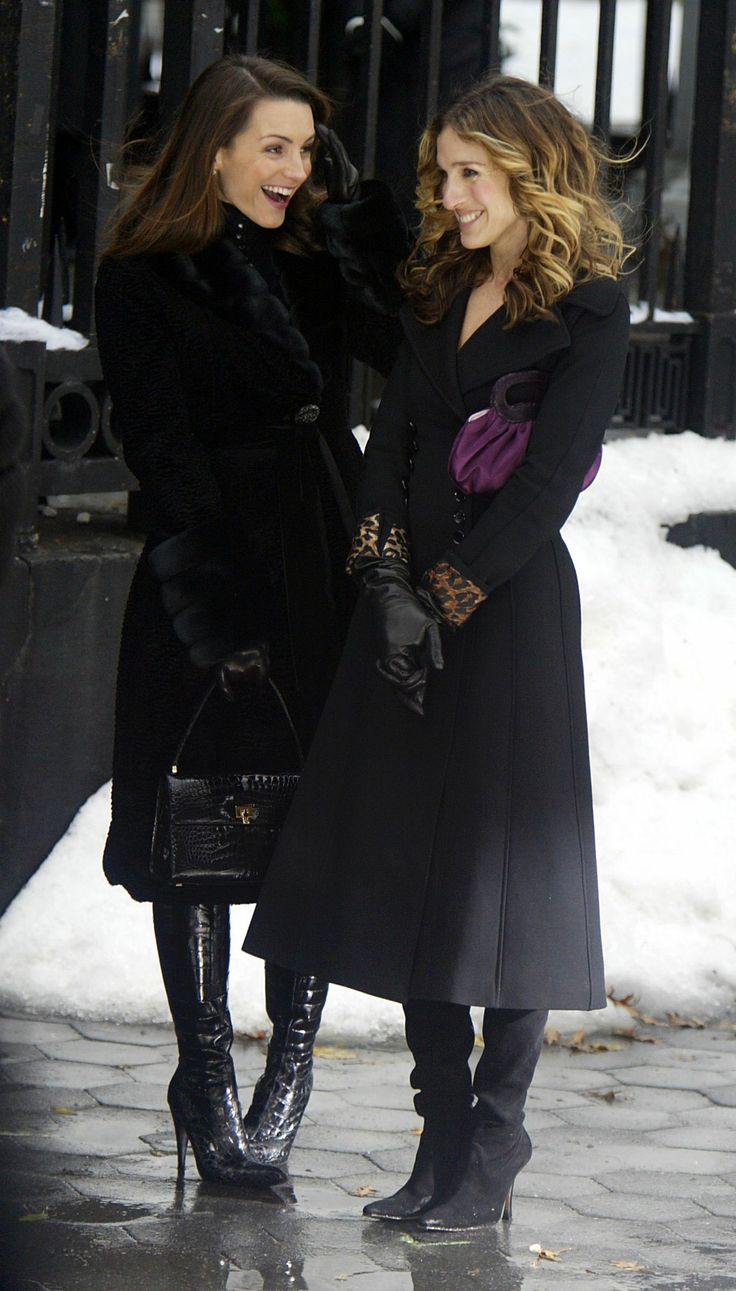 two women standing next to each other in the snow