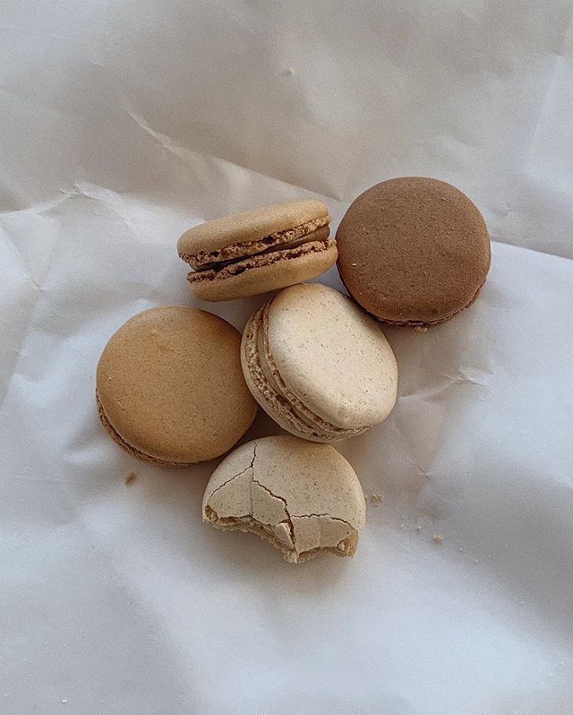 four macaroons are stacked on top of each other and one is half eaten