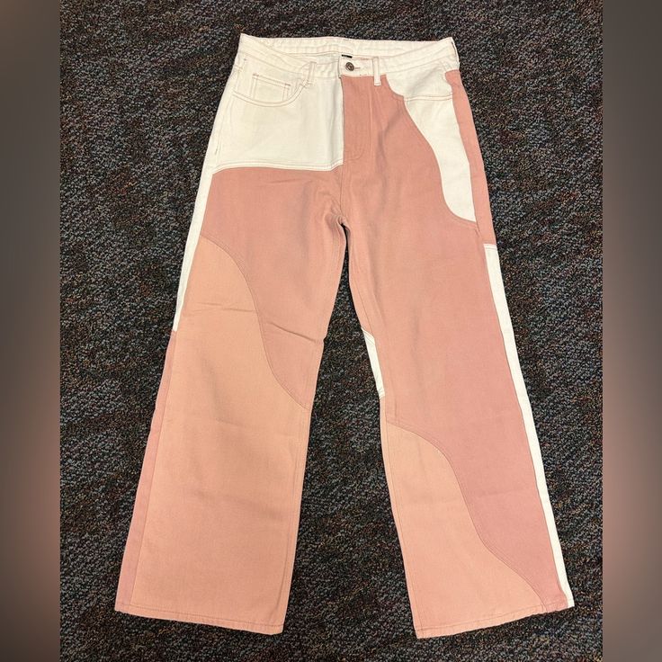 a pair of pink and white pants sitting on top of a carpeted floor next to a wall