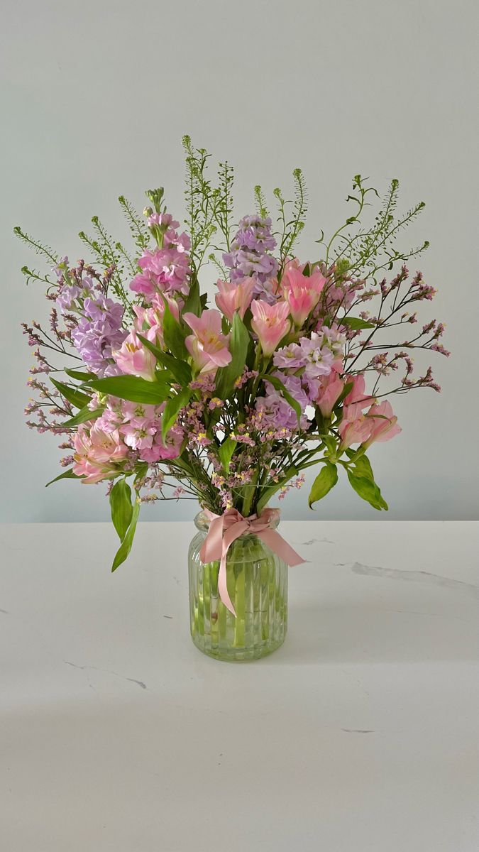 a vase filled with lots of flowers on top of a table