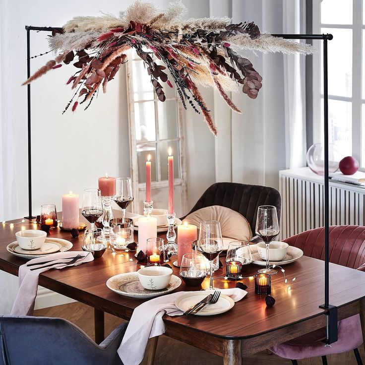 a dining room table is set with candles and plates