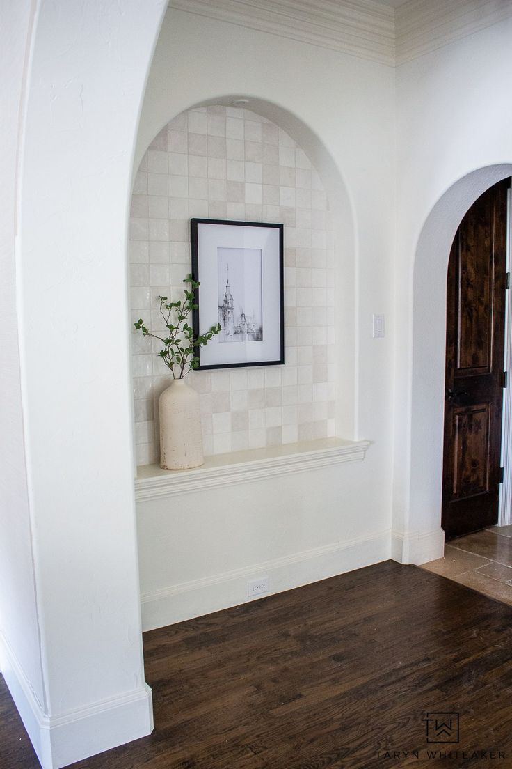 an arch in the corner of a room with a potted plant sitting on it