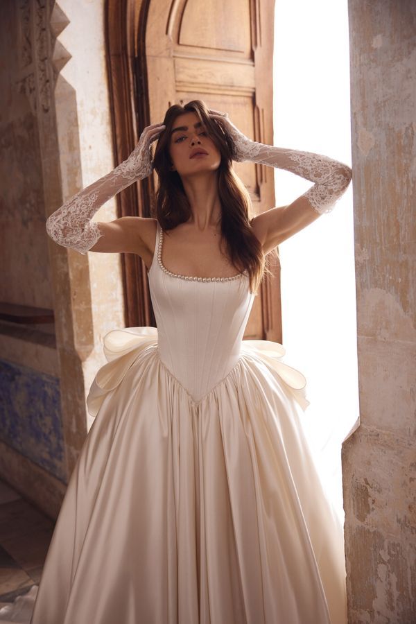 a woman in a wedding dress is posing for the camera with her hands on her head