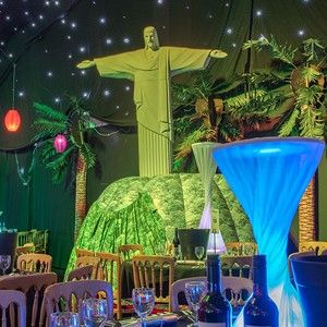 a table set up for a party with the statue of jesus in the background