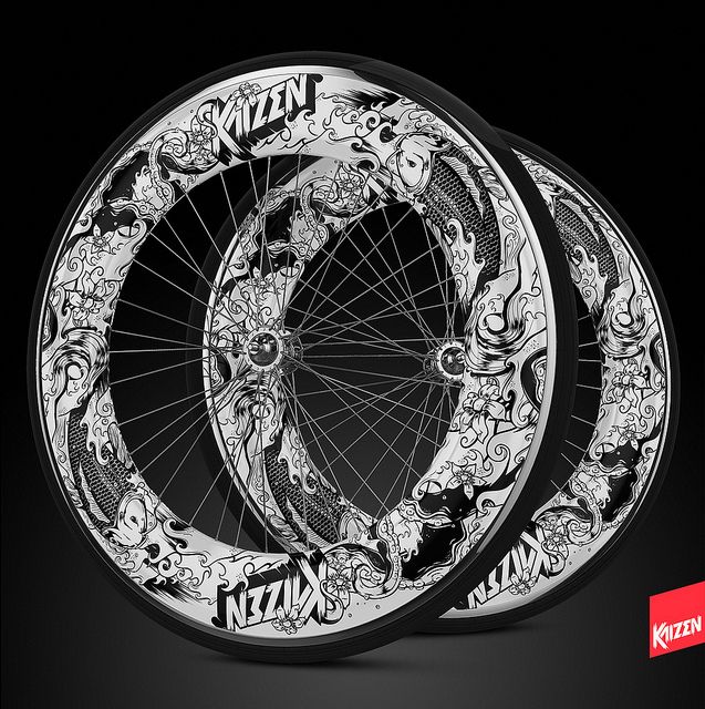 two bicycle wheels with skulls and flowers on the rims are shown against a black background