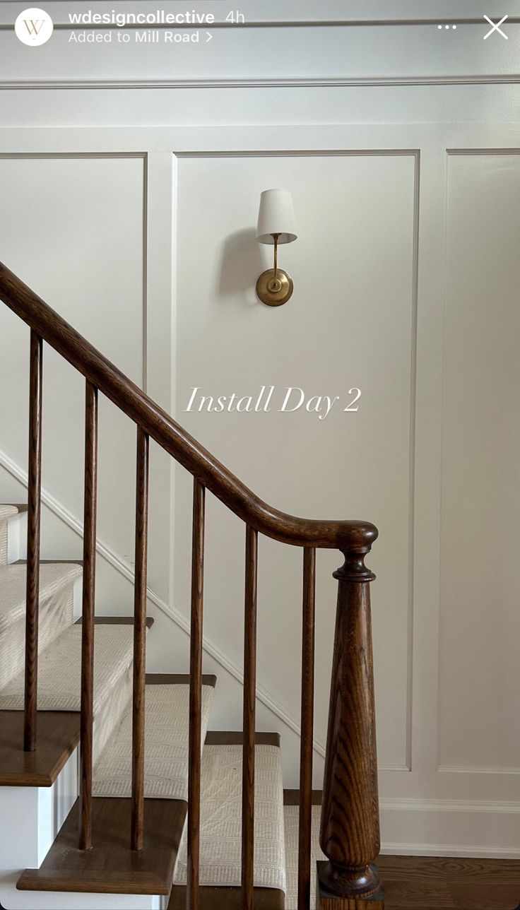 the stairs in this house have been painted white and are next to a lamp on the wall