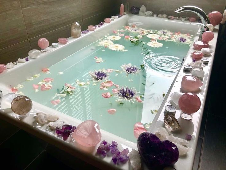 a large bathtub filled with lots of water and flowers floating in it's sides