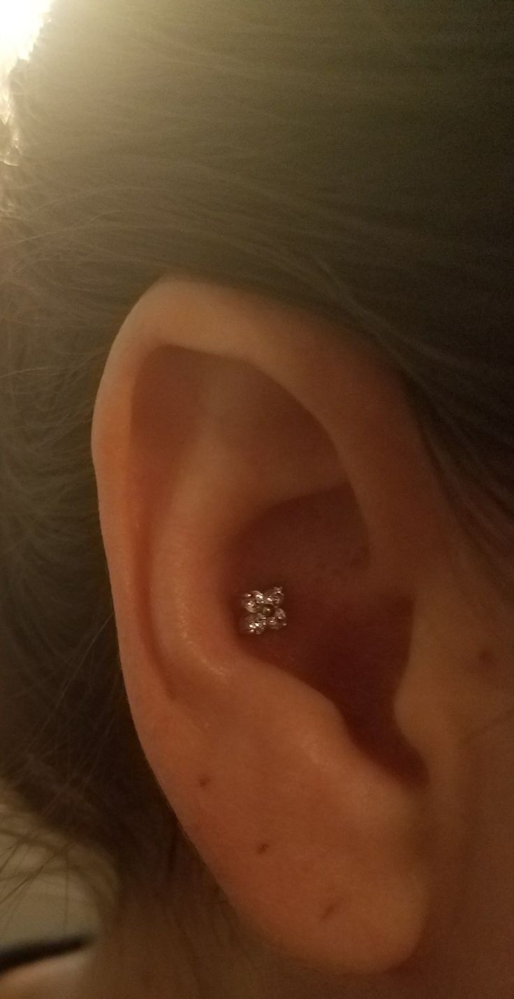 a woman's ear with a single diamond in it