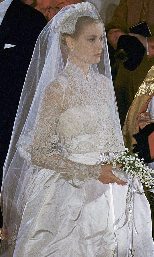 the bride is walking down the aisle in her wedding dress and tiara with an older man standing next to her