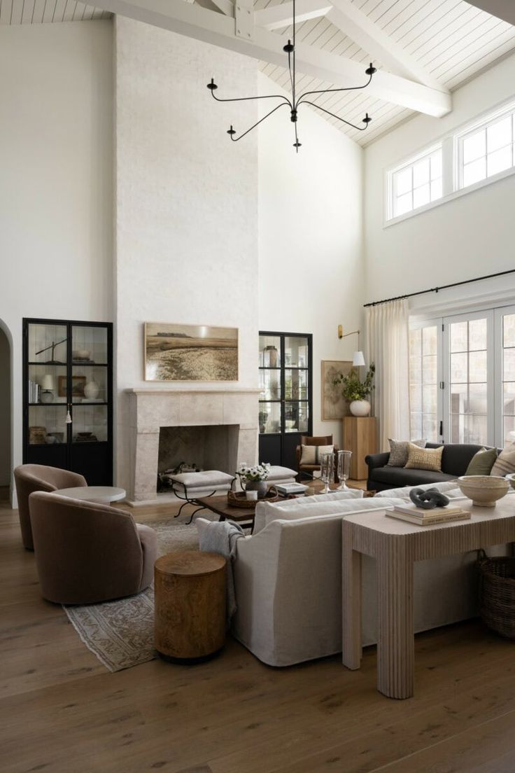 a living room filled with furniture and a fire place in the middle of an open floor plan