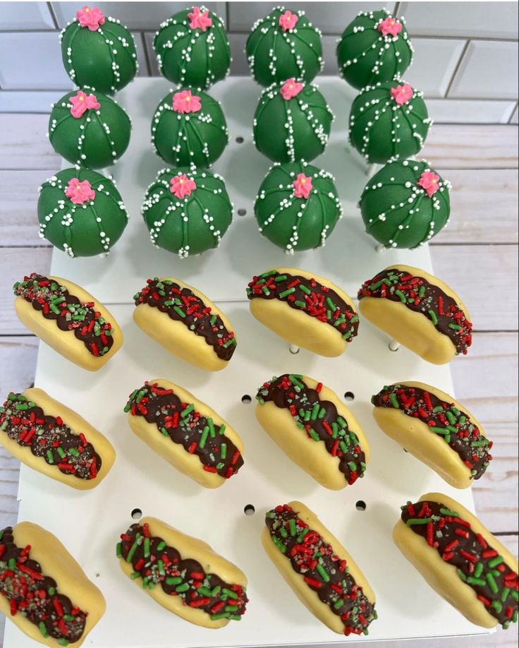 there are many decorated hotdogs on the table with green frosting and sprinkles