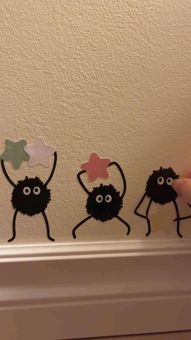 three black and white stickers with stars on them, one is holding a star