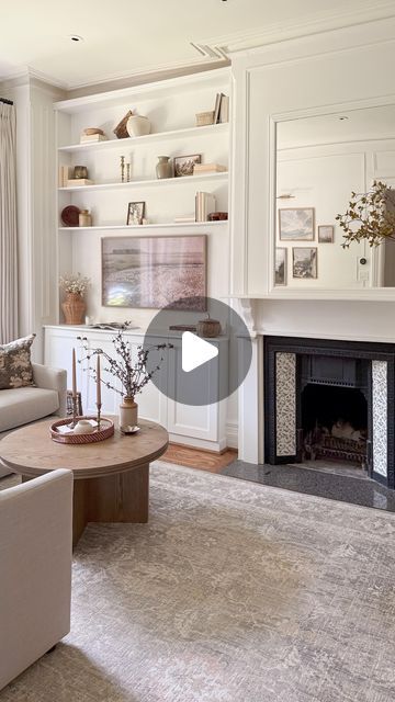 a living room filled with furniture and a fire place in front of a white fireplace