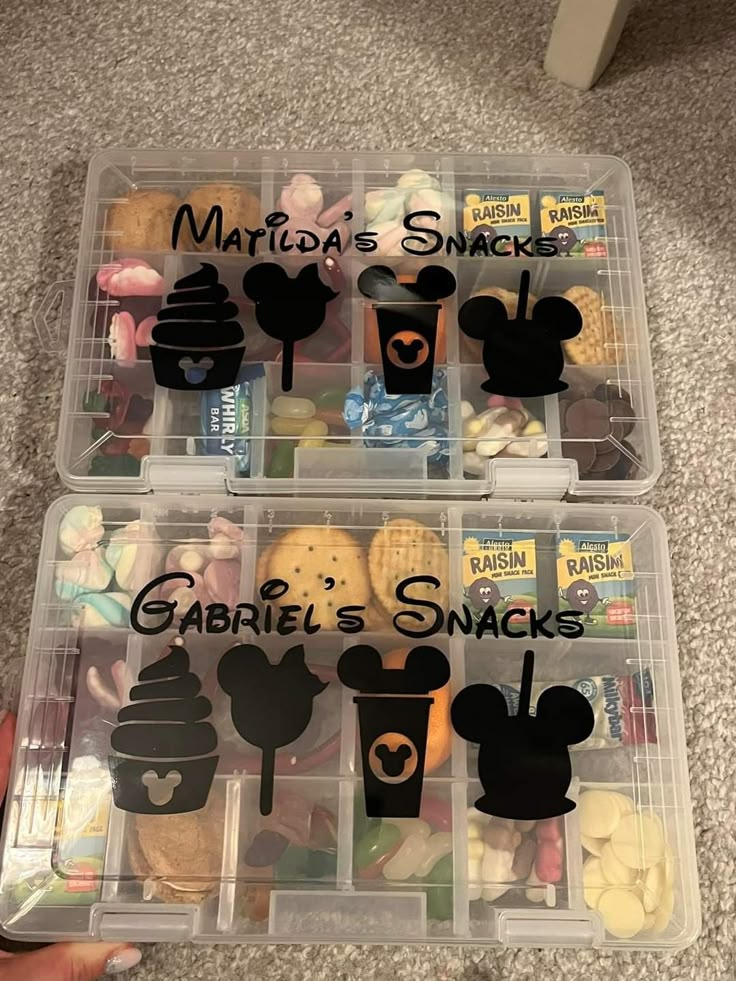 two plastic containers with mickey mouse snacks in them