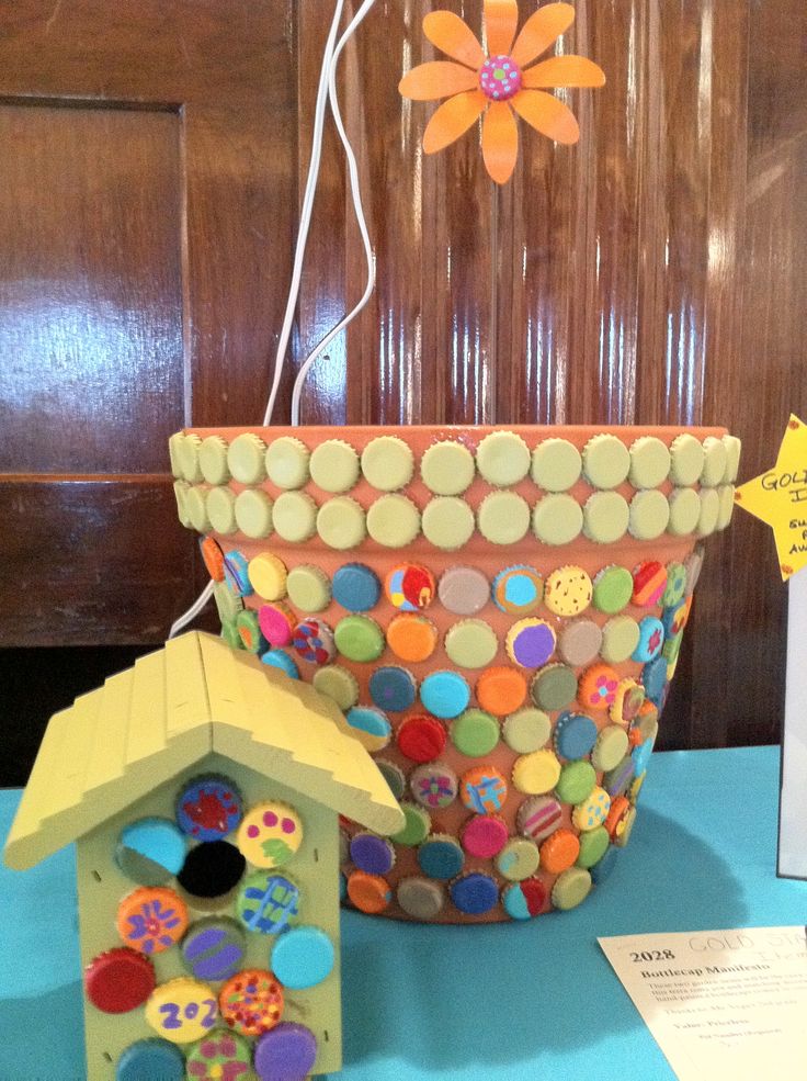 there is a birdhouse made out of buttons in the shape of a flower pot