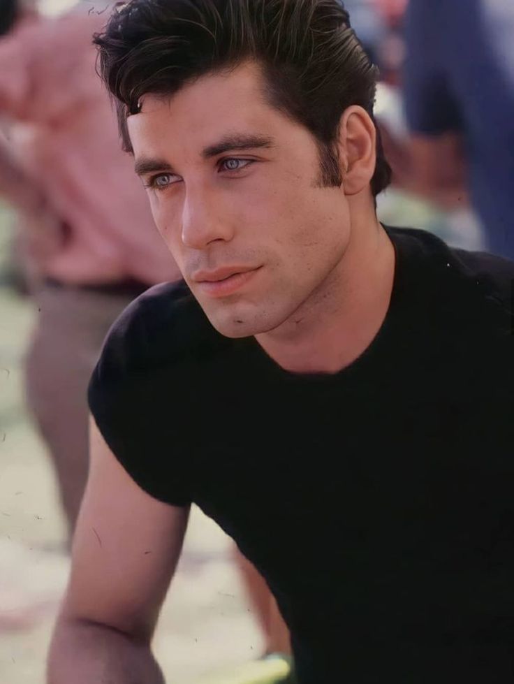 a young man sitting on top of a surfboard in front of other surfers