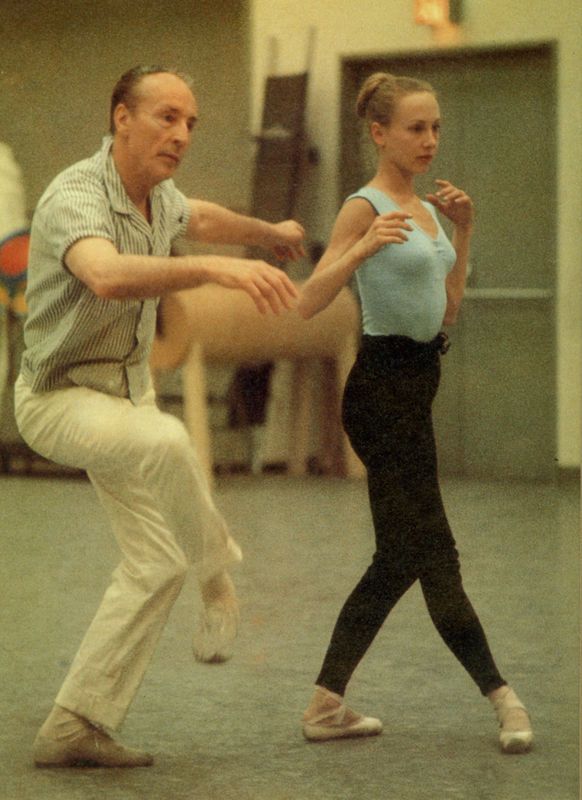 an older man and young woman are dancing in a dance studio, one is holding the other's leg