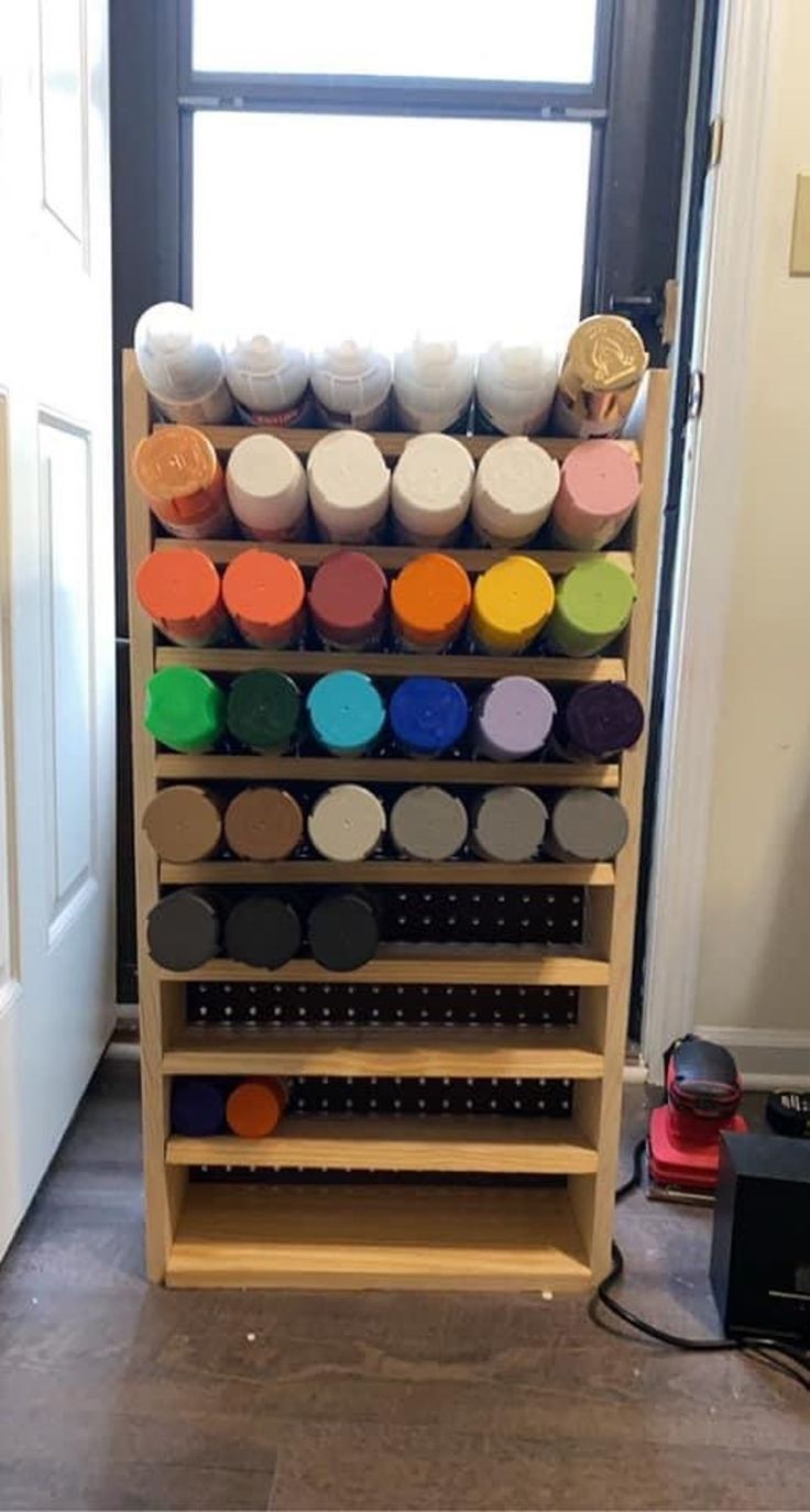 a wooden shelf filled with lots of different colored paint