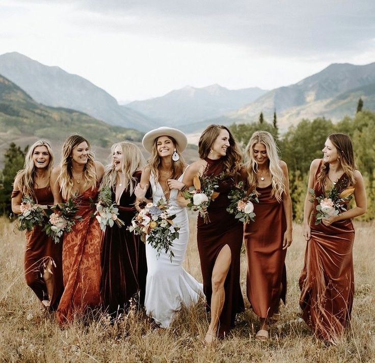 a group of women standing next to each other on top of a grass covered field